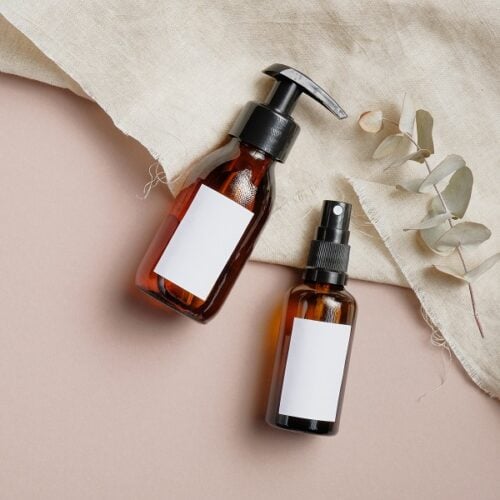 Amber glass cosmetic bottles set with towel and eucalyptus leave